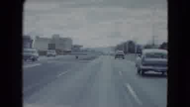 Nevada USA (1959): Moderate Traffic Of Cars On Three-Lane Highway In Urban Area On