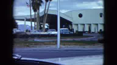 Nevada USA (1959): A Road With Buildings On One Side And Water On The Other Side