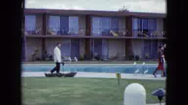Nevada USA (1959): A Man In A White Suit Walking Alongside A Swimming Pool