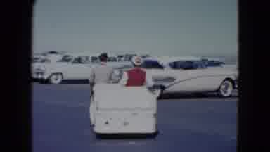 Nevada USA (1959): A Female Getting Escorted To Her Vehicle In A Parking Lot