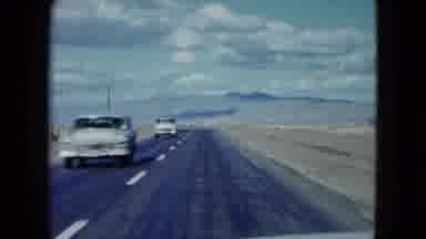 Nevada USA (1959): Car Driving Down A Highway In A Very Empty Landscape That Might