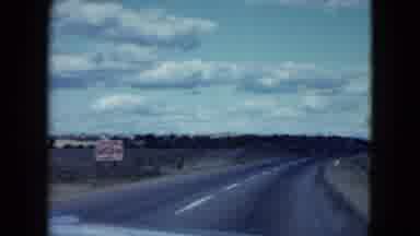Nevada USA (1959): A View Of A Car Driving Down A Deserted Street And Desert