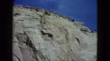 Nevada USA (1959): Driving Scene Of Rock Mountains Featuring Signs For Restaurants