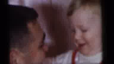 Camden New Jersey (1960): Man Smiles At Baby Wearing Red And White Striped Shirt
