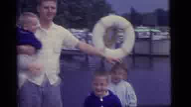 Camden New Jersey US (1960): Man Standing On Boat Dock Holds Young Child While Two
