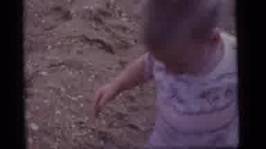 Camden New Jersey US (1960): Child Plays On A Sandy Beach Under The Watchful Eye