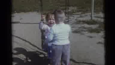 Camden New Jersey USA (1960): Girl Sitting On Swing With Boy Observing Then Girl