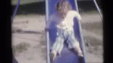 Camden New Jersey USA (1960): Girl Wearing White Sweater Slides Down Slide On A