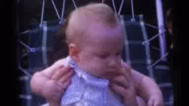 Camden New Jersey USA (1960): Woman Holds Baby Wearing Blue Shirt On A Bright
