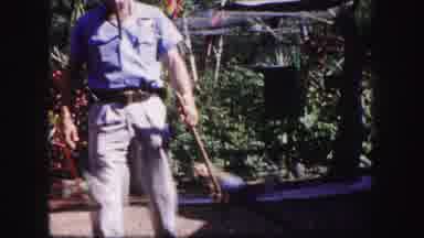 Tampa Florida USA (1960): A Man Walks Around With A Parrot On A Stick While Other