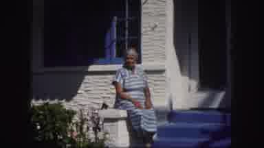 Tampa Florida USA (1960): Woman Wearing Blue Dress Sits On White Railing On A