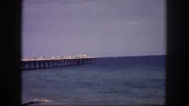 Tampa Florida USA (1960): Man And Woman Couple Walking On A Beach Near A Pier At