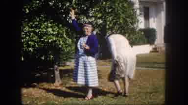 Tampa Florida USA (1960): Women Standing By A Tree On The Lawn Grabbing An Item