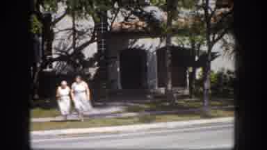 Tampa Florida USA (1960): Two Women Wearing White Dresses Prepare To Cross Street