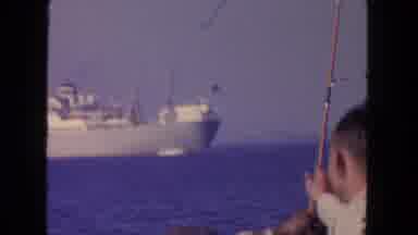San Diego California (1962): Men Fishing On A Boat With Ships In The Distance