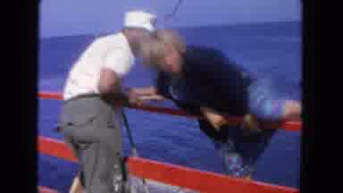 San Diego California (1962): Lady In A Blue Dress Climbing Over A Rail Onto A Dock
