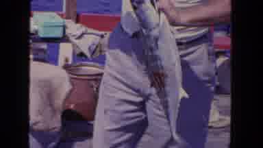 San Diego California (1962): Man Wearing White Shirt Removes Hook From Fish On A
