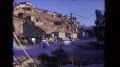 Los Angeles California USA-1962: Girl Wearing Red Shirt Runs Past White Wooden Sign