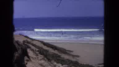 Los Angeles California USA (1962): Waves Crashing On A Sandy Beach With Clear Blue