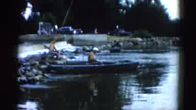 Illinois USA (1962): Man Casting Fish Line Near River Sitting On Short Near Boat