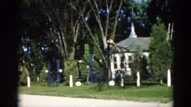 Illinois USA (1962): Two Young Adults Climbing A Tree In The Summer In A Cottage