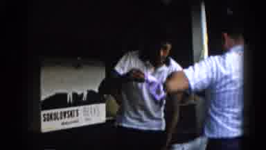 Illinois USA (1962): Person Wearing White Shirt Selling Items From White Wooden