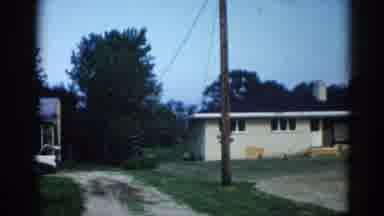 Illinois USA (1962): View Of Blue Car Parked Next To Tan And Yellow Building On A
