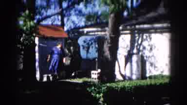 Illinois USA (1962): Two Women Enjoying Backyard Flowers And Trees On A Windy Day