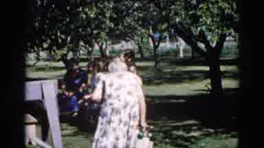 Illinois USA (1962): Grandma Walks Over To The Group Of Women Sitting On The Bench