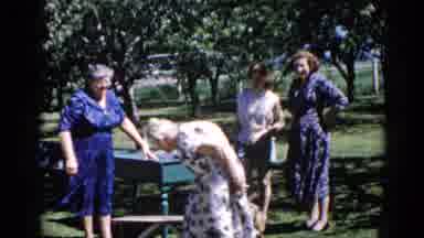 Illinois USA (1962): Elderly Woman In White Floral Dress Sitting On Bench In Park