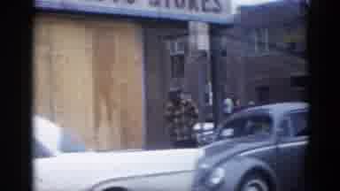 Illinois USA (1962): A Vehicle Drives Through An Old Town With A Decrepit Building