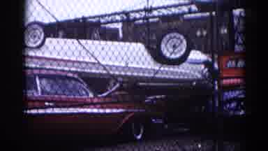 Illinois USA (1962): Through Fence Red Car And White Car Stacked On Each Other