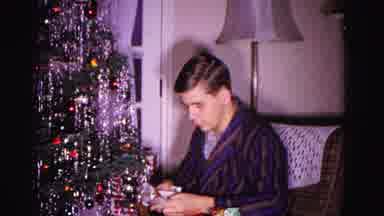 Hagerstown Maryland USA (1962): Man Opening Christmas Present Beside The Tree