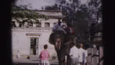 Calcutta India-1962: Tourists Ride Elephant Past Colonial Building As Others Watch