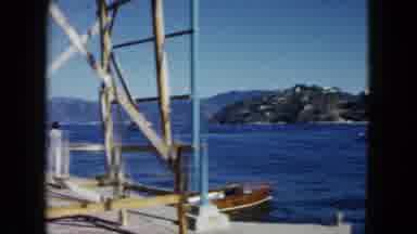 Acapulco Mexico (1962): Woman In White Dress Walking Next To Blue Water Small Boat