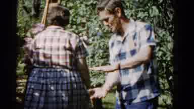 Wauconda Illinois USA (1961): Woman Holding Purple Flowers Walks Towards Brown