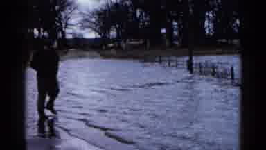 WAUCONDA ILLINOIS USA-1961: Man Fishes On Flooded Road Near House