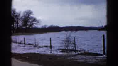 Wauconda Illinois USA (1961): Flood Waters Pass Through A Fence And Over A Road On
