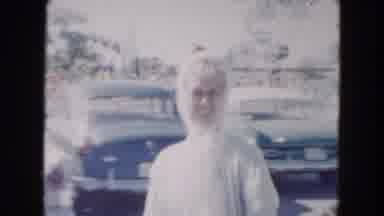 South Carolina USA (1961): Dog Swims In Water On Sunny Day While Woman Waves At