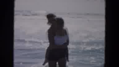 SOUTH CAROLINA USA-1961: Mother Plays With Baby In The Ocean By Dunking Baby's