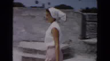 South Carolina USA (1961): An Adult Women Walks Past While Two Young Girls Play