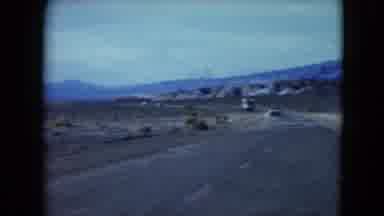 Nevada USA (1961): Driving Down The Road In The Desert Between The Mountains