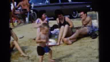 Camden New Jersey USA (1961): A Boy Plays On The Beach While Three Adults Look On