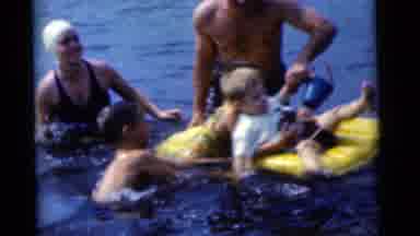 Camden New Jersey USA (1961): Adults Watch As Children Play On A Water Toy A Man
