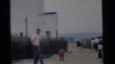 Camden New Jersey USA (1961): People Walking Towards A Lighthouse Building On A