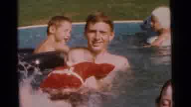 Camden New Jersey USA (1961): Man Holds Kicking Child Wearing Red Watervest In