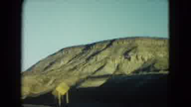 Nevada USA (1960): Moving Scene Of Rocky Hills And Long 2 Lane Highway With Small