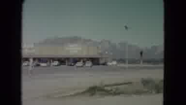 Nevada USA-1960: A Parking Lot With Vehicles Nestled At The Foot Of Some Mountains