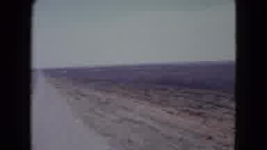 Nevada USA (1960): Camera Pans Across The Desert Landscape That Is Cut By The Road