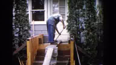 Wauconda Illinois USA (1960): Man Standing On Porch Cleaning Something As An